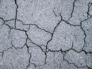 Burst asphalt texture. The road is in need of repair. Old grain effect.