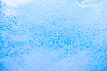 water foam and bubbles of blue color as background. cosmetology concept