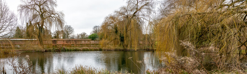Ornamental lake bordered by a large brick wall.