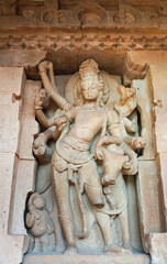 Fototapeta na wymiar Aihole, Karnataka, India - November 7, 2013: Durga Gudi or Temple. Beige-brown stone massive statue of Shiva leaning on nandi.