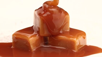 melted caramel sauce flowing on caramel candies close up