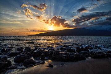 Obraz premium Sun setting behind the West Maui Mountains from Kihei Beach