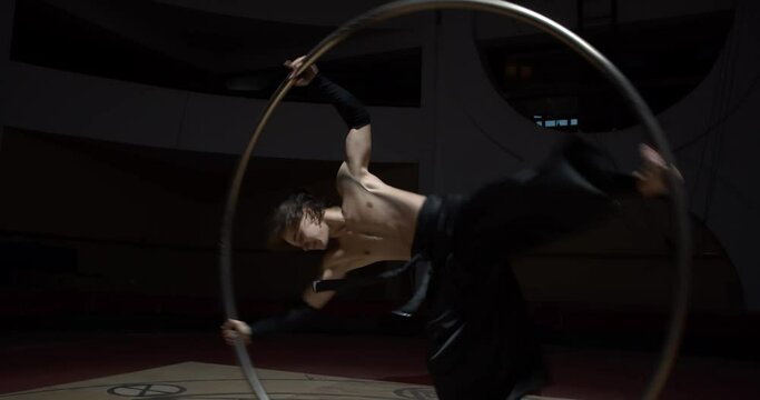 Upside down spin in a metal hoop, wheel gymnastics by a circus performer, 4k