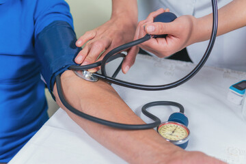 Senior man on medical check-up checking blood pressure
