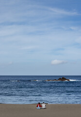 Two people sitting on beach, lovers enjoying, good weather, Azores, Sao Miguel.