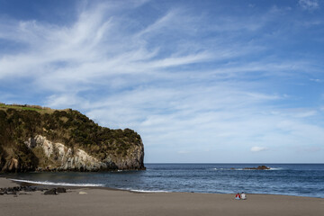 Fototapeta na wymiar Two people sitting on beach, lovers enjoying, good weather, Azores, Sao Miguel.