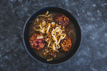 plant-based food, vegan crumbed beetroot patties in savoury broth with onion and lentils