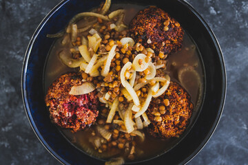 plant-based food, vegan crumbed beetroot patties in savoury broth with onion and lentils