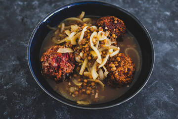 plant-based food, vegan crumbed beetroot patties in savoury broth with onion and lentils