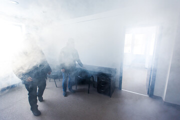 Smoke from a fire in the room. Two people stand in a room amid thick smoke and wait for rescuers.