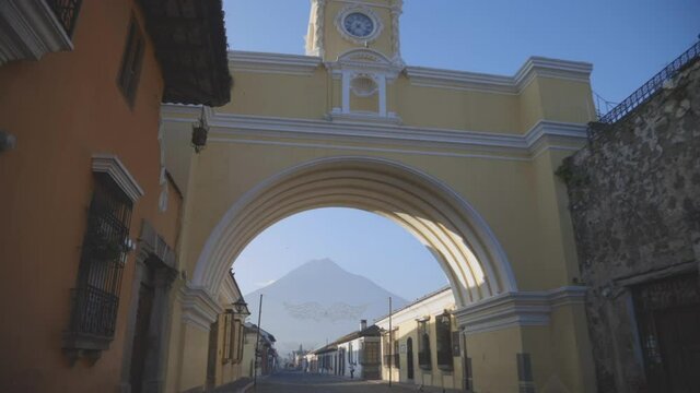 Arch of Santa Catalina in Antigua Guatemala with the blue sky in the background early in the morning - emblematic square in Antigua Guatemala with the water volcano in the background 