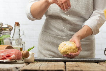 Chef prepares dough using flour in a bright kitchen Ingredients, recipe book, cooking and gastronomy