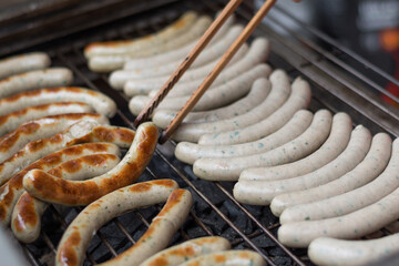 With Tongs Rotate Person Frying Sausages On Grill