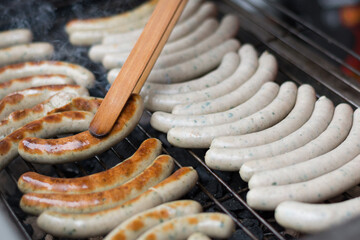 With Tongs Rotate Person Frying Sausages On Grill