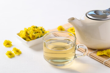 Organic Chrysanthemum flower tea in a cup and teapot on white background, Healthy Herbal drink