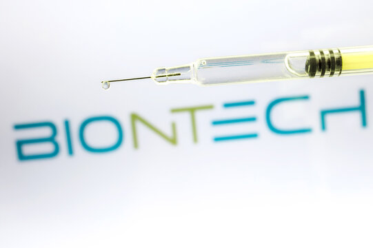 Syringe with liquid drop against BionTech logo, a German biotechnology company based in Mainz