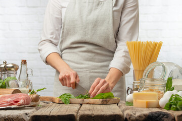 The chef is preparing a salad or dish, the chef cuts the basil leaves. Ingredients Cooking & Recipe Book