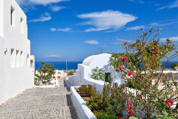 View of the beautiful blue Aegean Sea and Caldera from the whitewashed hillside town of Oia on a summer day in Santorini, Greece.