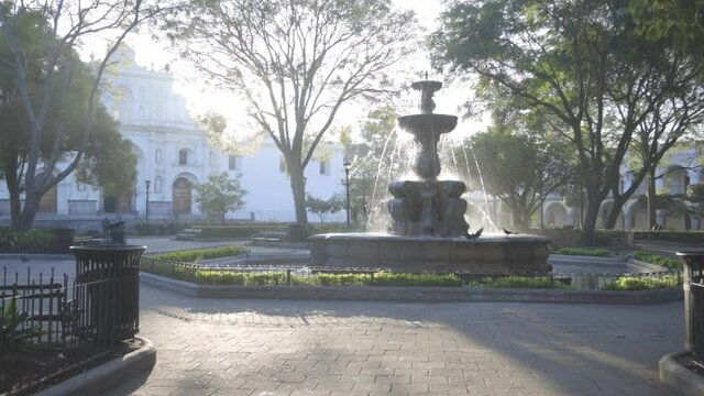 Sunrise at Mermaids Fountain in the central park of Antigua Guatemala - first rays of the sun over beautiful colonial park with a fountain in Antigua Guatemala 