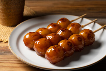 Mitarashi dango and green tea on a wooden background