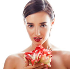 Fototapeta premium young pretty brunette real woman with red flower amaryllis close up isolated on white background. Fancy fashion makeup, bright lipstick, creative Ombre manicured nails