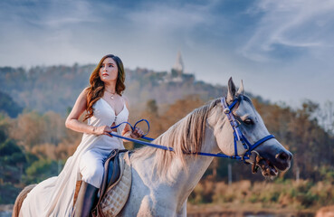 Beautiful girl riding a horse on nature in sunset time