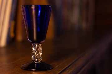 Blue Crystal Cup. Wooden Bookshelf Background