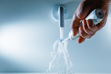 hand holding toothbrush under flowing water from faucet in a hospital