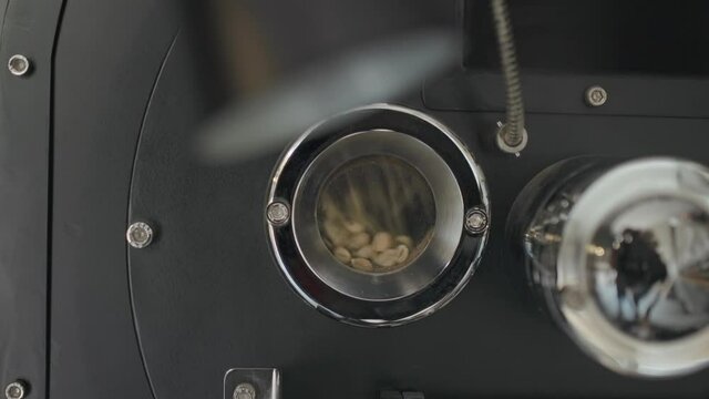 Small Glass Window Opening of Coffee Roasting Machine with Large Metal Furnace, Tumbling inside Vigorously in slowmo