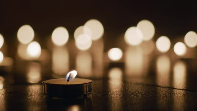 A lit tealight flickers in front of a beautiful bokeh backdrop. Great for romantic posts, valentines day and more. In stunning 4k.