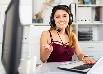 Young woman call centre operator with headphones working in modern office