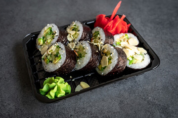 Traditional Japanese rolls with avocado vegetables and cucumber in box