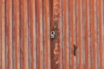 Red metal door closed on the lock corrugated steel fence gate padlock garage shed in Sofia, Bulgaria, Eastern Europe
