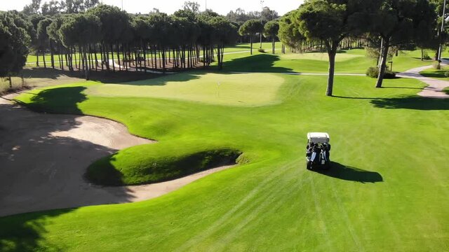 Flying over and following golf cart in golf course field, Turkey