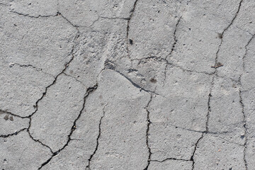 Grey texture of old broken asphalt road or wall big abrasions cracks holes on the surface pebbles cement in Sofia, Bulgaria, Eastern Europe