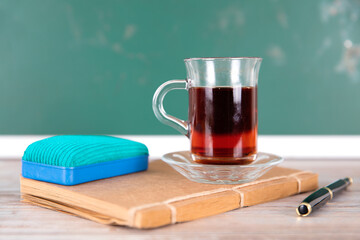 A cup of black tea in front of the blackboard