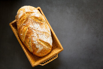 Loaf of homemade craft bread in a wicker basket. For breakfast, lunch and dinner. With copy space 