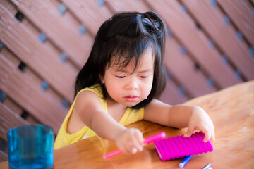 The kid girl cried and didn't want to write a book. Children study at home. An Asian girl aged 3 -...