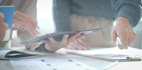 Young female financial inspector working on laptop computer and checking document.