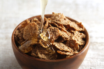 はちみつを注いでいる朝食のシリアル