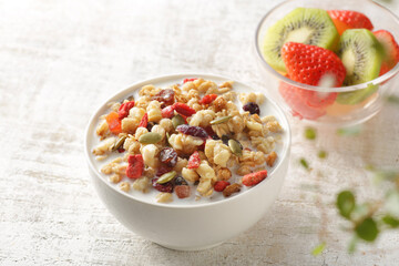 ミルクを注いだ朝食のシリアルやフレークと果物