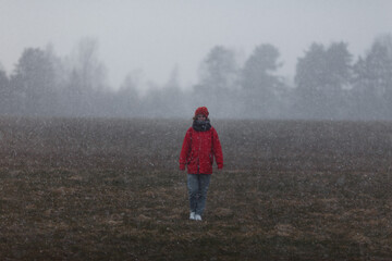 Girl in the field and snowfall. 
