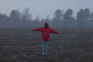 Fototapeta na wymiar Girl in the field and snowfall. 