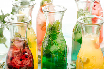 Side view on assorted fresh fruit lemonades with herbs