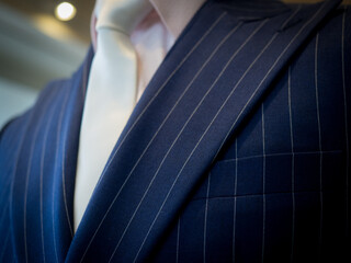 close up of dark blue suit with pink shirt and white tie