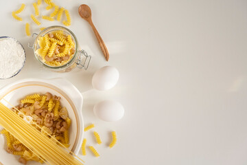 Assorted Italian pasta. On a white background. View from above. Pasta on a plate. Flour, eggs and pasta made from them