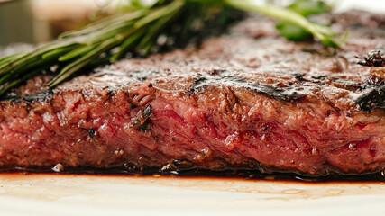 Closeup on roasted beef medium rare steak with a rosemary