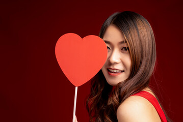Beautiful of young woman with red heart. Smiling happy valentine's day. lady showing heart on red background
