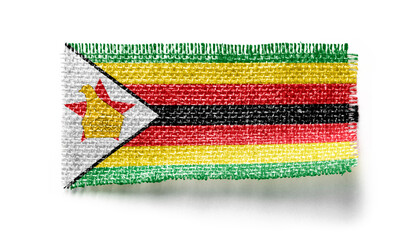 Zimbabwe flag on a piece of cloth on a white background