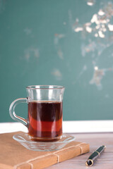 A cup of black tea in front of the blackboard